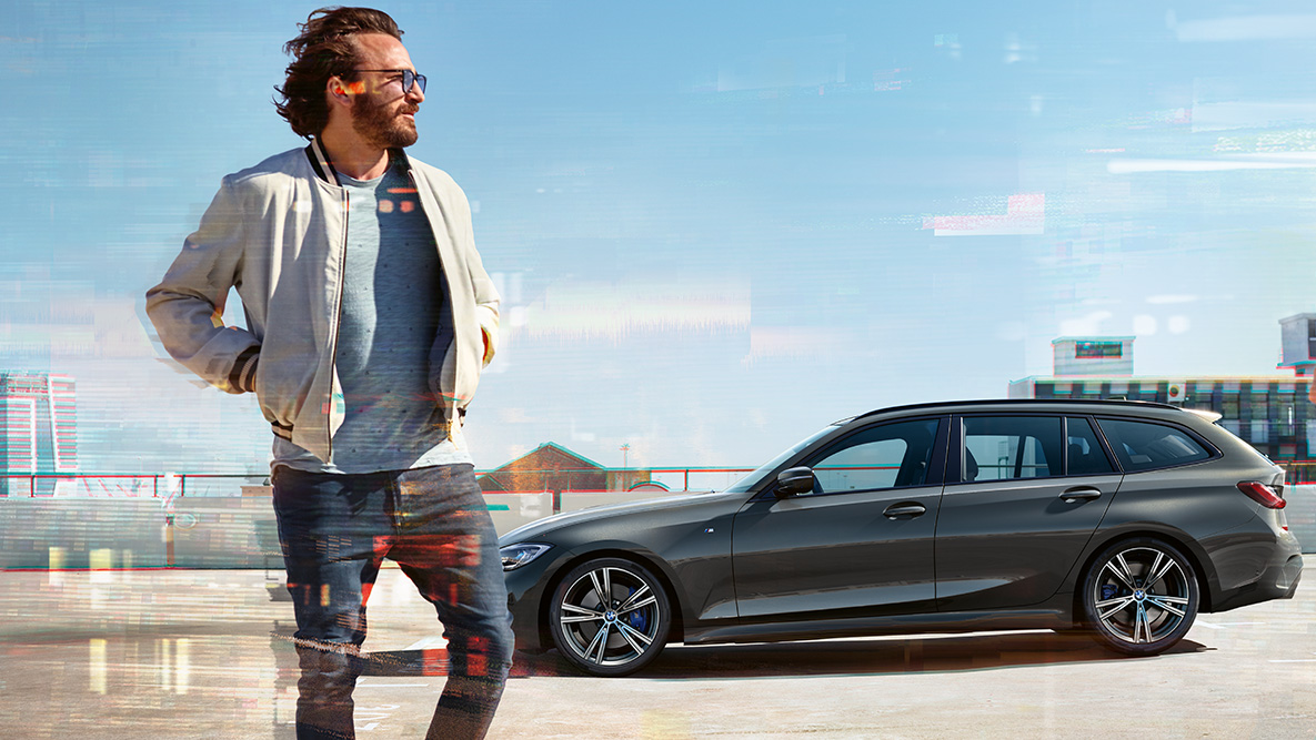G21 BMW 3系列Touring,四分之三車頭照,設計 G21 BMW 3系列Touring,dravite grey色,在鄉村環境前行駛於橋上,四分之三車頭照