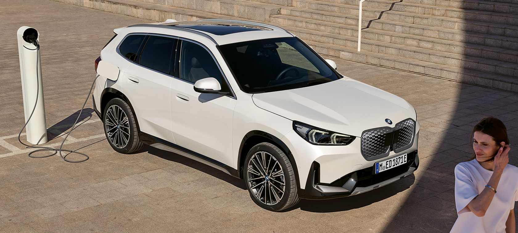 U11 BEV BMW iX1,車側充電 U11 BEV BMW iX1,Mineral White銀粉漆,三分之二車側視角,充電中,階梯