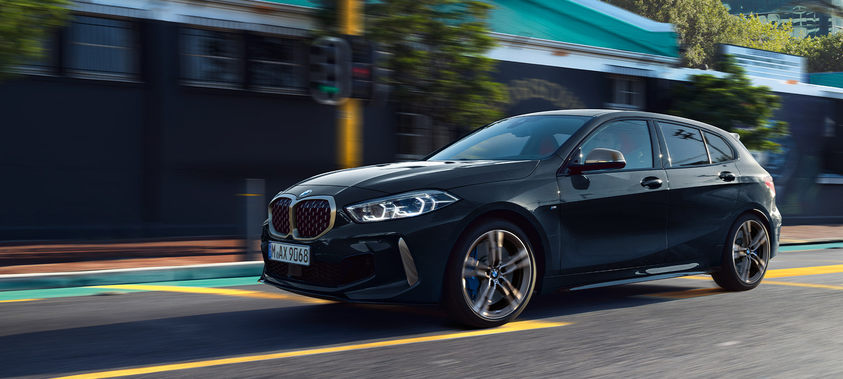 F40 BMW M135i xDrive搭配Black Sapphire銀粉漆，於都市環境，行駛中