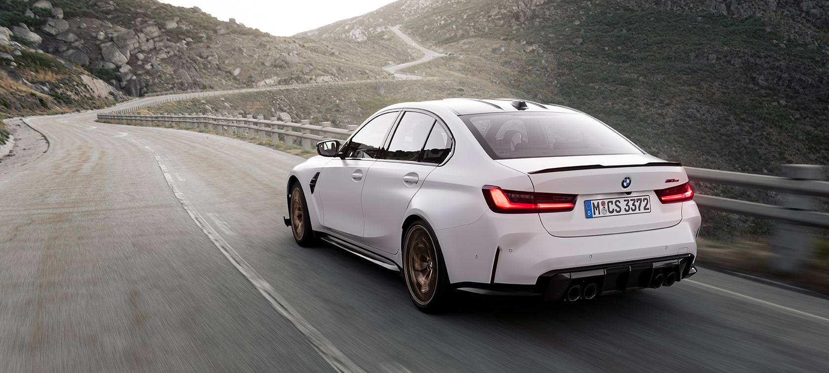 BMW M3 CS G80,四分之三車尾視角行駛中 BMW M3 CS G80,四分之三車尾視角行駛於山路上
