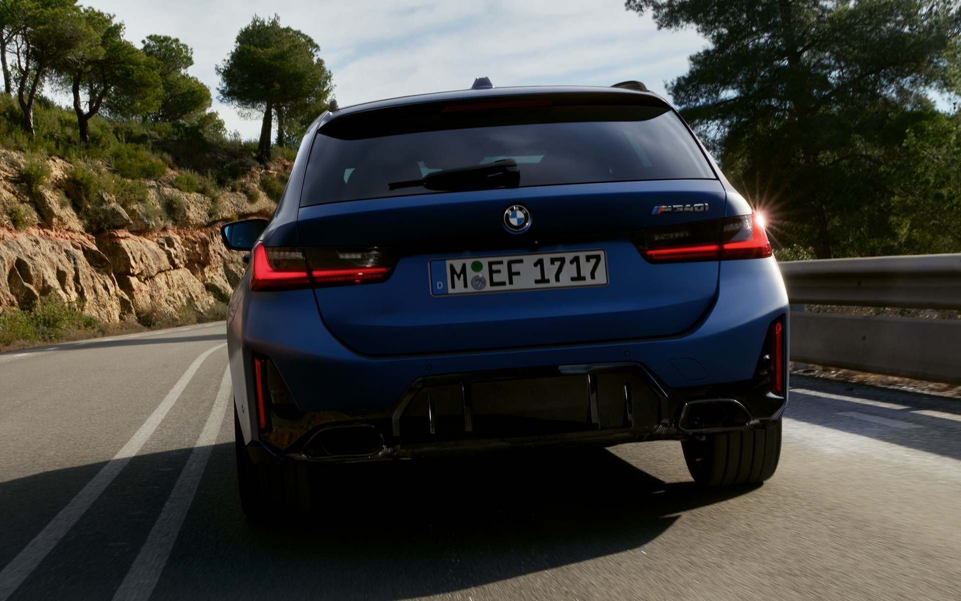 G21 BMW M340i xDrive Touring，Frozen Tanzanite Blue，車尾視角，行駛於街道上