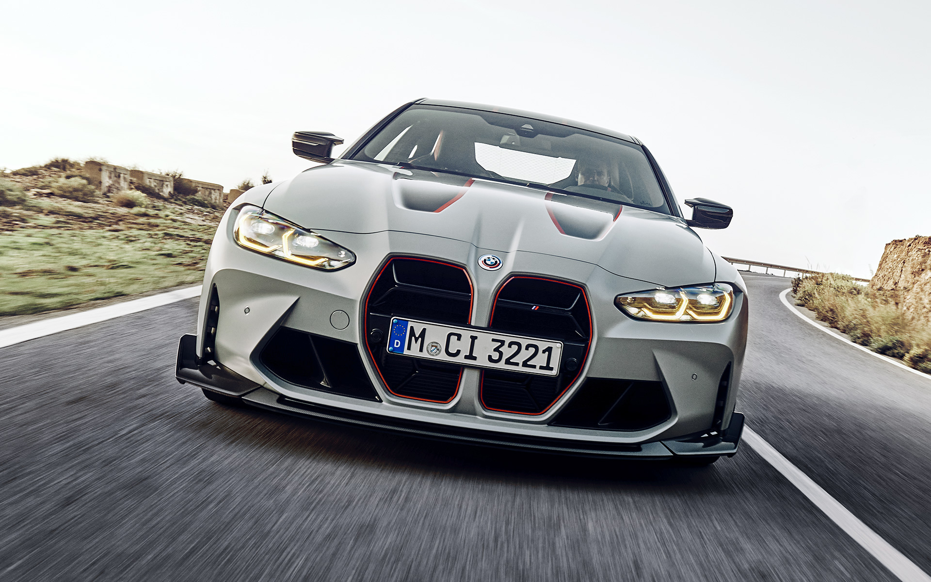 G82 BMW M4 CSL,黑色雙腎型水箱護罩直柵搭配專屬紅色貼紙 G82 BMW M4 CSL,BMW Individual Frozen Brooklyn Grey銀粉漆,黑色雙腎型水箱護罩直柵搭配專屬紅色貼紙,車頭視角,行駛於街道上