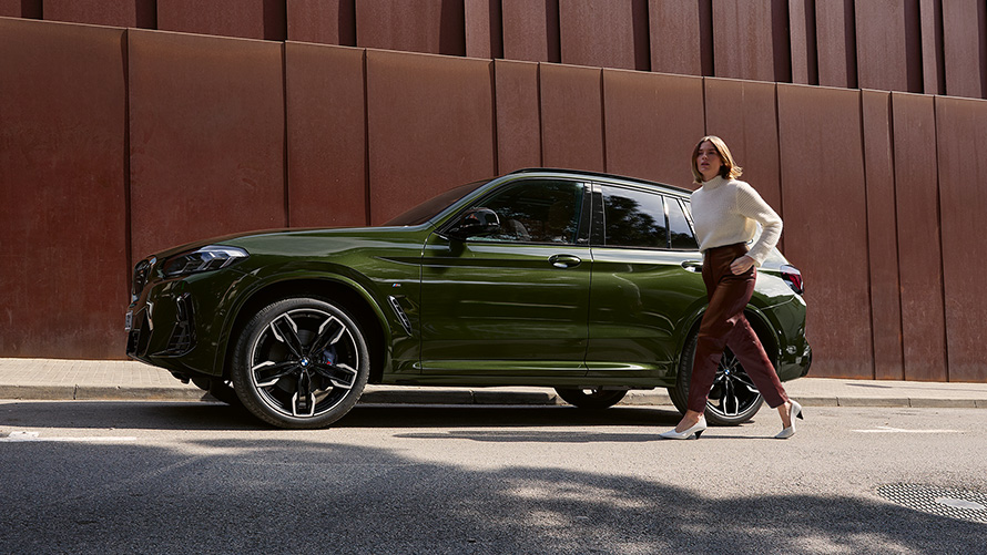 G01 BMW X3 M40i LCI嶄新風貌，Malachite Green銀粉漆，車側視角與女性模特兒