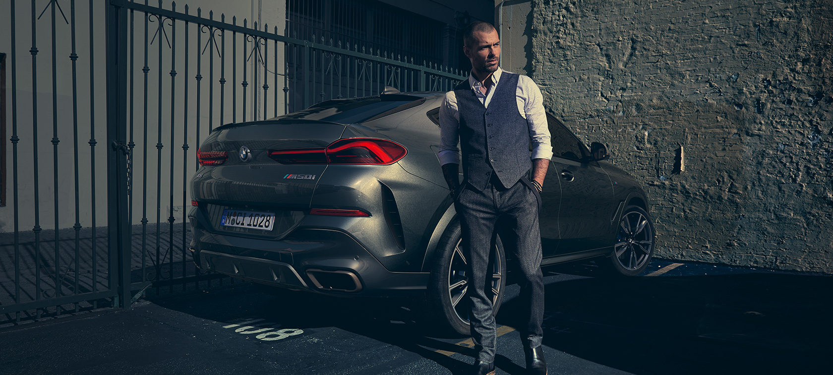 G06 BMW X6 M50i,四分之三車尾視角 2018 SUV G06,男人站在BMW X6 M50i,四分之三車尾視角