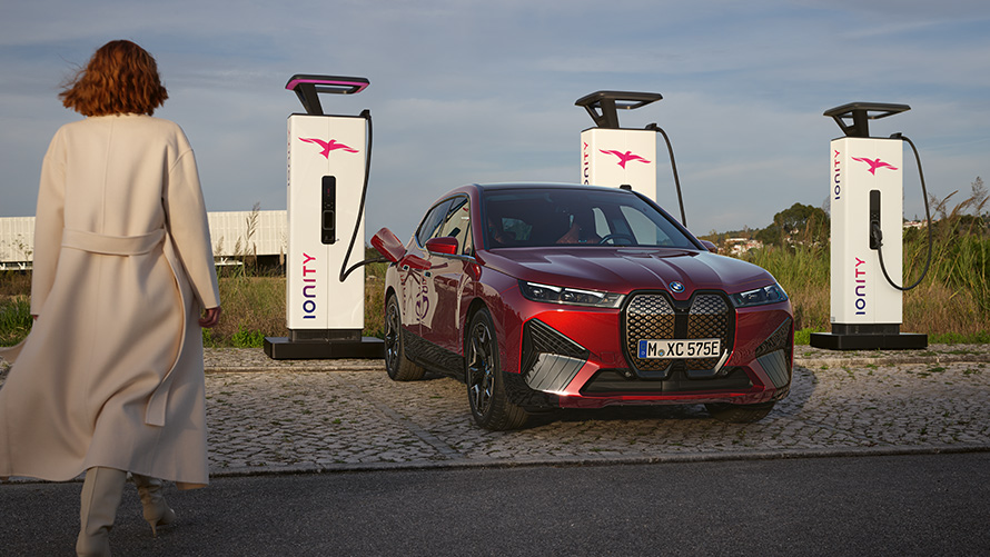 BMW特殊銷售,永續發展,概覽,BMW充電方案 BMW特殊銷售,永續發展,概覽,BMW充電方案,女人站在充電樁前的BMW汽車前