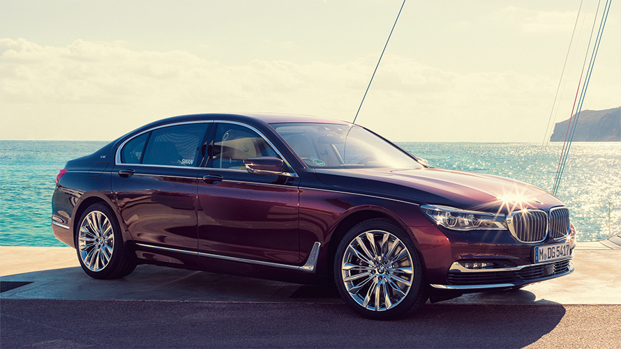 以Nautor’s Swan為靈感的G12 BMW Individual M760Li，靜止，於海灣碼頭帆船前，四分之三車側視角