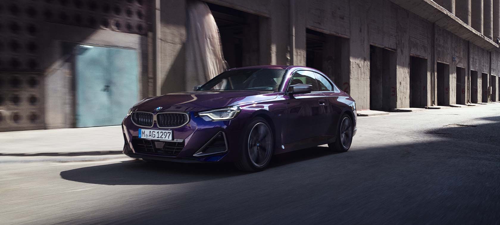 BMW 2 Series three-quarter front view driving on road in front of landscape BMW 2 Series BMW three-quarter front view driving on road in front of landscape