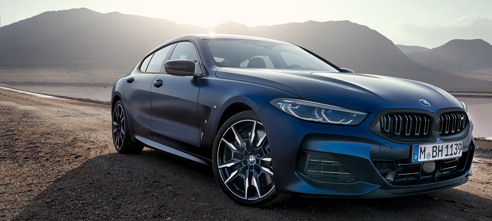 G16 BMW 8系列Gran Coupé LCI嶄新風貌，BMW Individual Frozen Tanzanite Blue銀粉漆，四分之三車頭視角，行駛於山路上