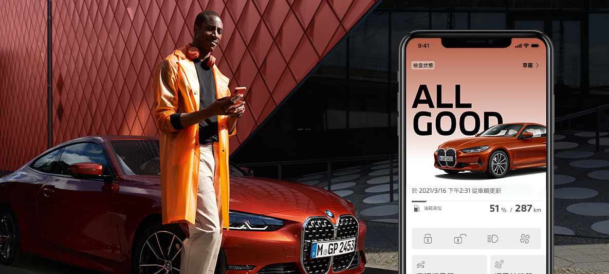 於BMW 4系列雙門跑車前使用My BMW App 檢查車輛狀態的男士